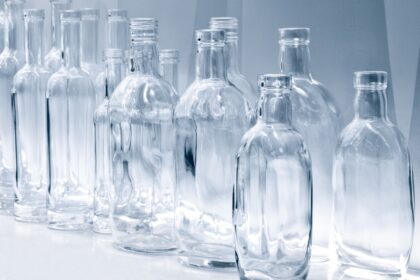 Empty,Glass,Bottles,In,A,Row,On,A,Shelf,In