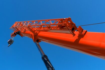 Construction,Crane,Arm,With,Hook,Against,Blue,Sky,Background.,Mobile