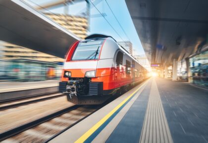 High-speed,Orange,Passenger,Train,Moving,At,Railway,Station,Platform,At