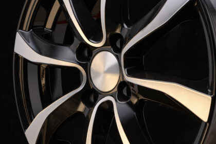 car alloy wheel close-up of the disc element, curves smooth lines of the wheel spokes, polished front surface. black background, concept