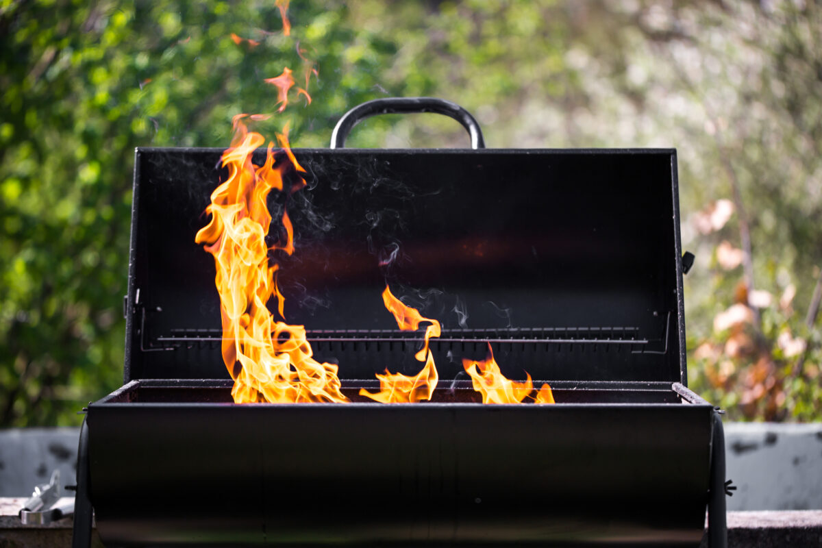 Man heats the bbq grill, preparing for grilling some kinds of meat