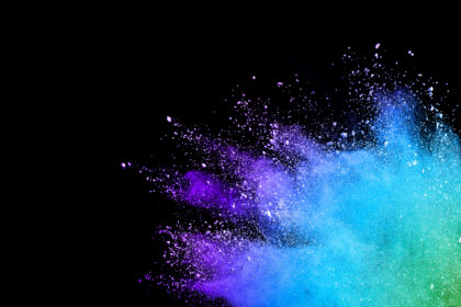 Splash of colorful powder over black background.