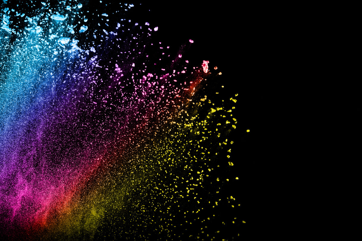 Multi color powder explosion isolated on black background. Colored dust splash cloud on black background. Launched colorful particles on background. Painted Holi.