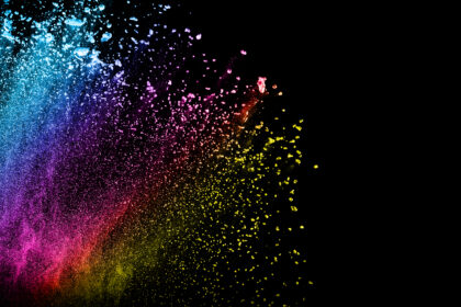 Multi color powder explosion isolated on black background. Colored dust splash cloud on black background. Launched colorful particles on background. Painted Holi.