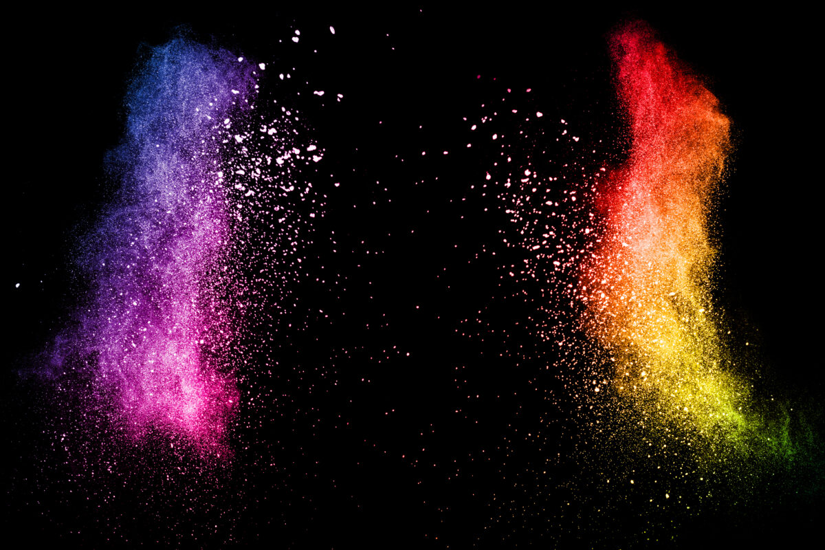 Multi color powder explosion isolated on black background. Colored dust splash cloud on black background. Launched colorful particles on background. Painted Holi.