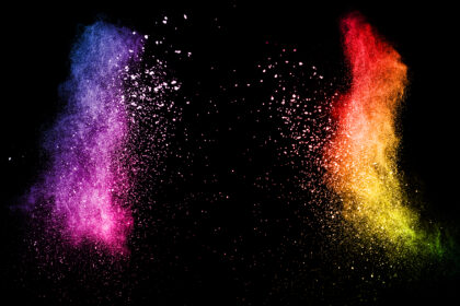 Multi color powder explosion isolated on black background. Colored dust splash cloud on black background. Launched colorful particles on background. Painted Holi.