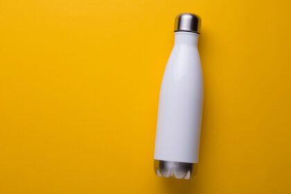 Reusable,White,Metal,Bottle,On,Yellow,Background