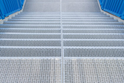 New staircase with perforated steps made from metal iron. Industrial background