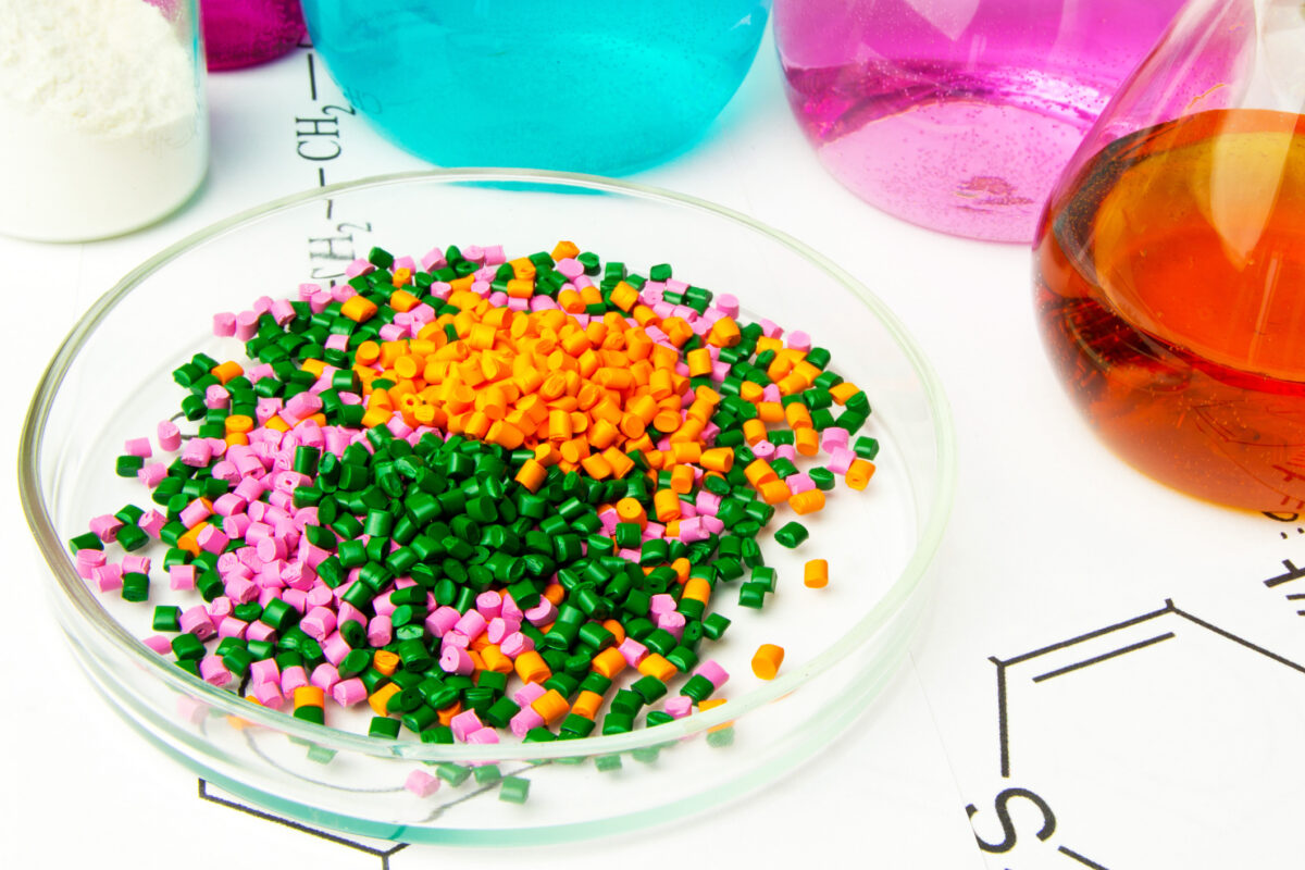 Plastic raw material in granules against the background of Chemical Laboratory and reagents. Polypropylene, Ethylene, Polypropylene research in laboratory conditionsPlastic raw material in granules against the background of Chemical Laboratory and reagent